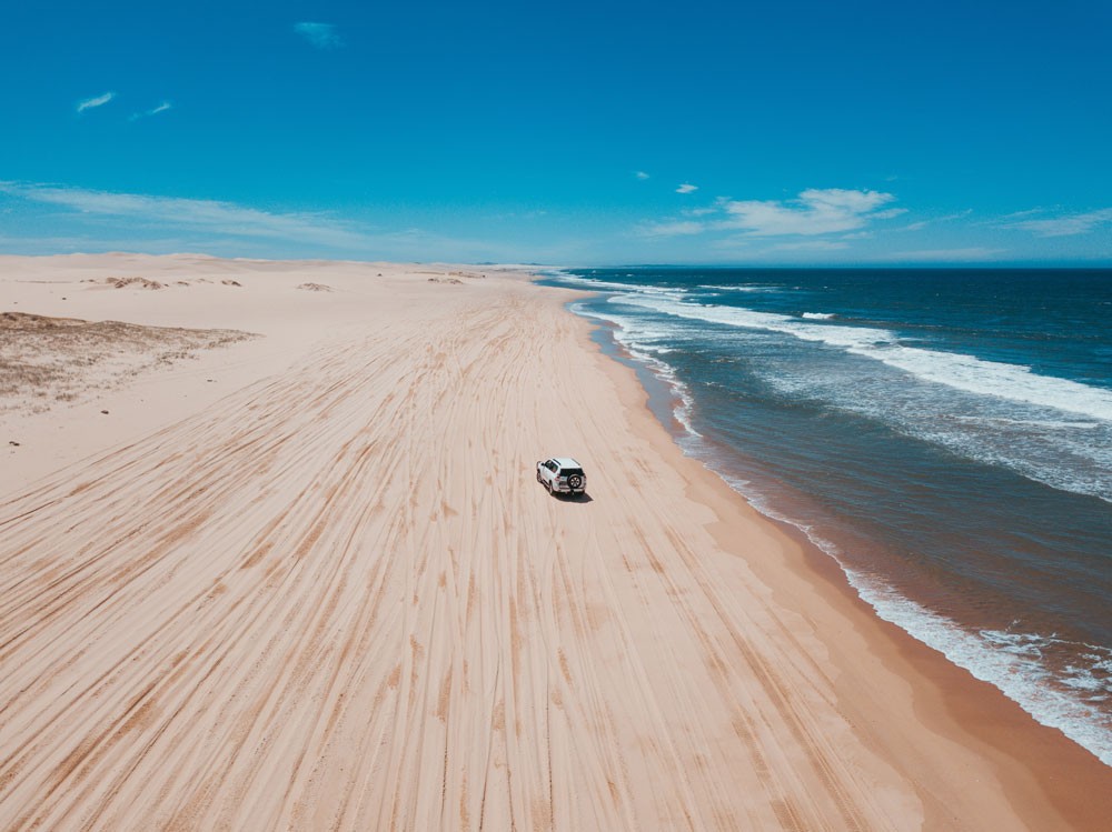 fotografía aérea de un coche circulando por la arena